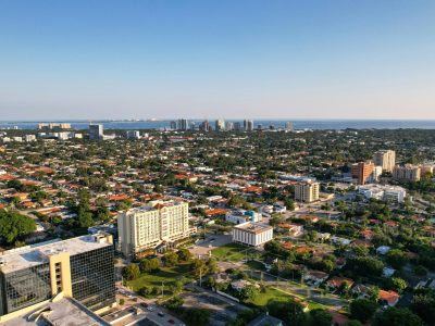 Aerial daytime view of Miami, Florida capturing city skyline and distant ocean.